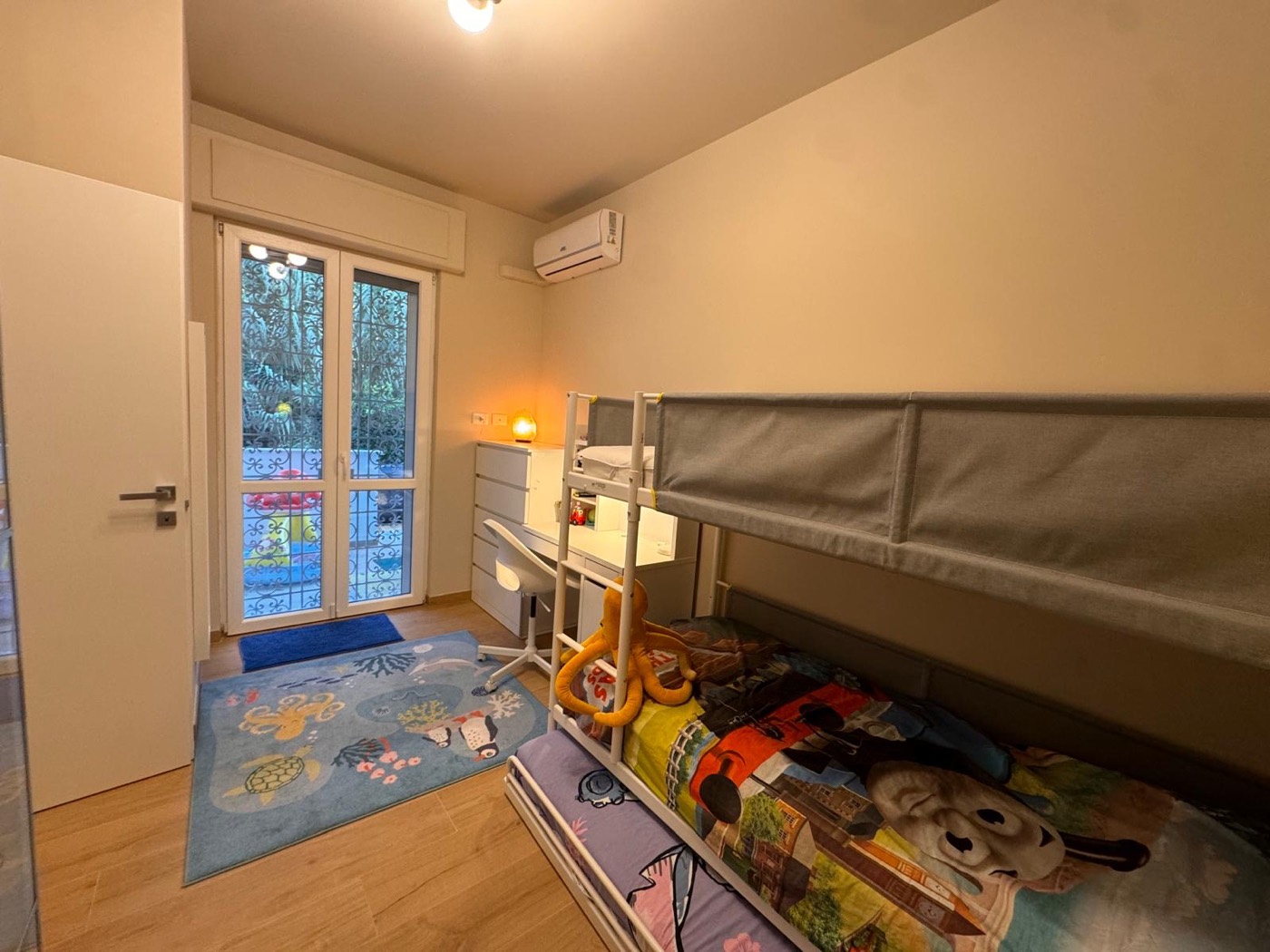 Cameretta con letto a castello e porta finestra sul giardino